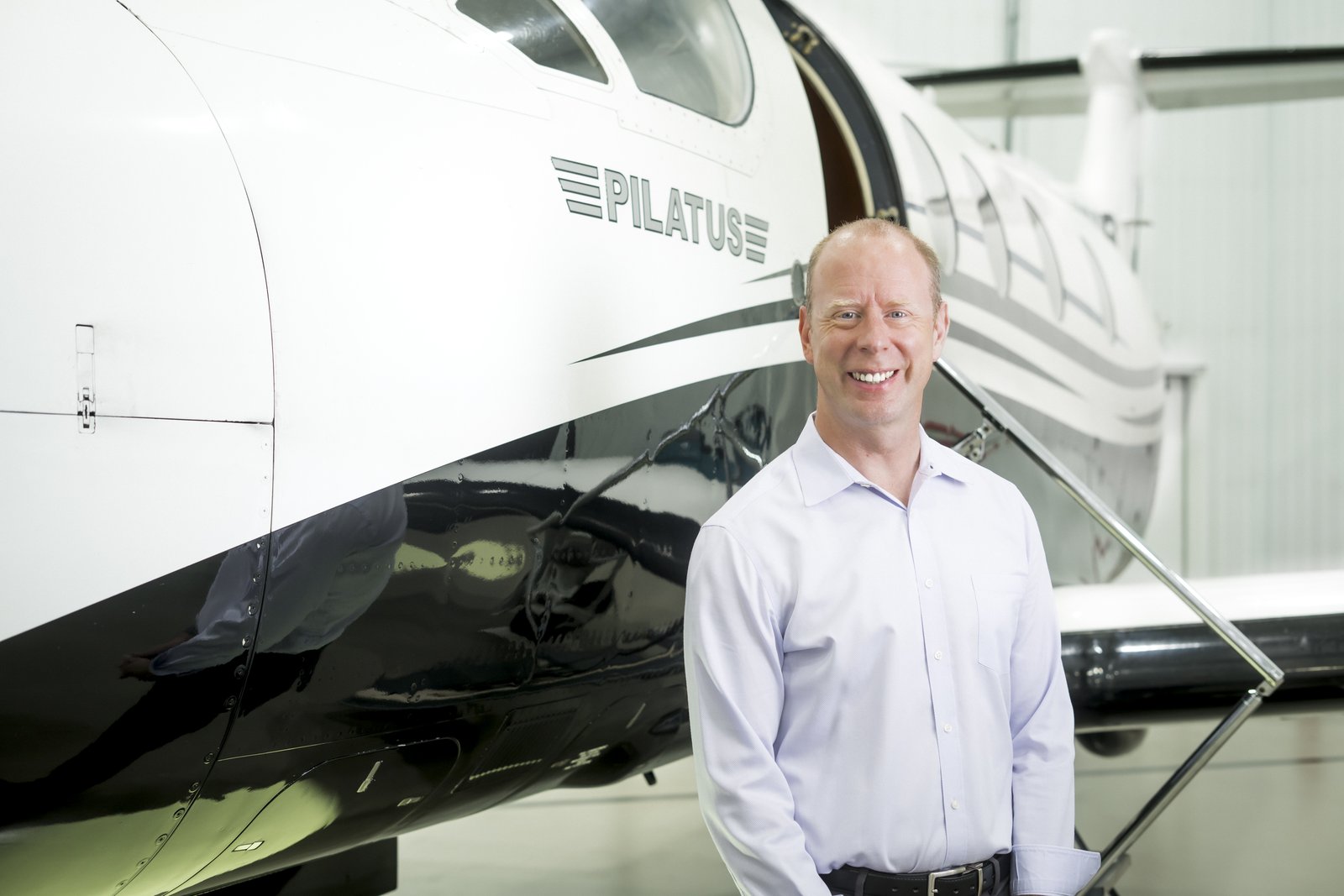 Ken Reily in front of a Pilatus PC-12 in the hangar